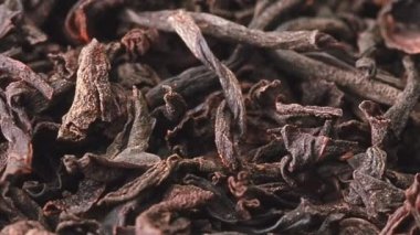 Kurumuş çay yaprakları yığını boyunca yavaşça kayan hareket, yakın çekim. Bir sürü kurutulmuş çay yaprağı, soyut arka plan. Seçici yumuşak odaklanma. Bulanık arkaplan.