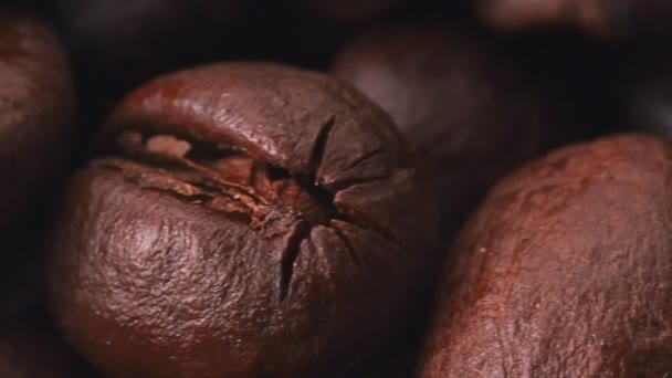 Café marron, prise de vue très rapprochée. Dolly shot de tas de grains de café torréfiés, fond abstrait. Mise au point sélective. Fond flou . — Video