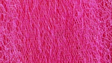 Kırmızı tekstil, makro çekim. Kamera yavaşça kırmızı kumaş boyunca kayıyor. Soyut arkaplan. Kırmızı kumaş dokusu. Seçici yumuşak odaklanma. Bulanık arkaplan.