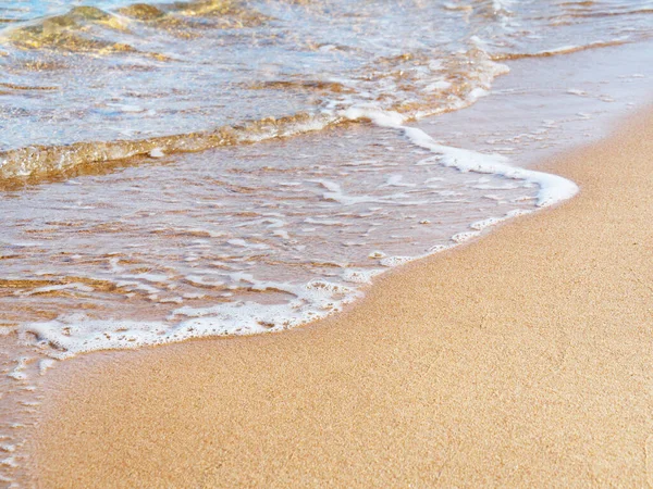 Rudé moře na žlutém písku, zblízka. Bílá mořská pěna na žlutém písku. Fotografováno v Egyptě. Přírodní pozadí. Selektivní měkké zaměření. Rozmazané pozadí. — Stock fotografie