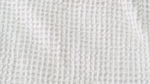 Serviette blanche, plan rapproché. Texture de textile blanc. Caméra glissant lentement le long du tissu blanc. Contexte abstrait. Mise au point sélective. Fond flou .