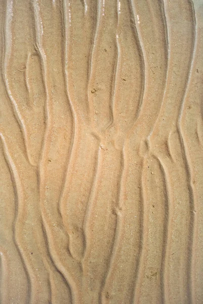 Ein abstraktes Muster auf gelbem Sand, Nahsicht. Textur aus gelbem Sand. Abstrakter Hintergrund. Strand am Roten Meer im Februar. — Stockfoto