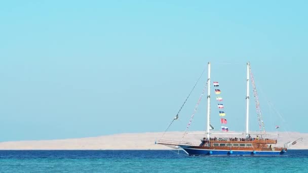 Turystyczny statek pływający po Morzu Czerwonym, ekstremalnie szeroki strzał. Błękitne niebo jest czyste. Sfotografowany w Egipcie w lutym. Selektywne miękkie skupienie. Zamazane tło. — Wideo stockowe