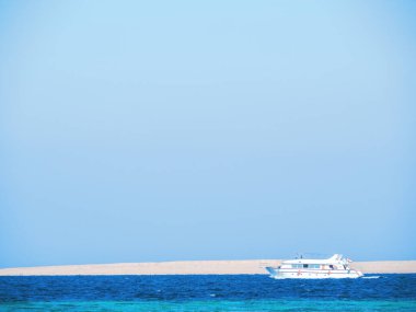 Kızıl Deniz 'de turistlerin dolaştığı beyaz bir tekne. Mavi gökyüzü temiz. Mısır 'da Şubat' ta çekilmiş. Seçici yumuşak odaklanma. Bulanık arkaplan.