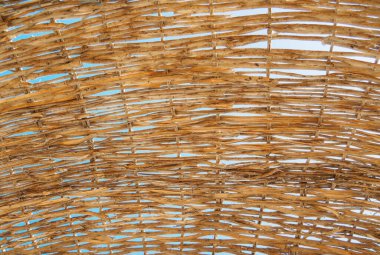 Bastondan yapılmış sarı plaj şemsiyesi, yakın görüş. Sarı baston deseni, soyut arkaplan. Seçici yumuşak odaklanma. Bulanık arkaplan.