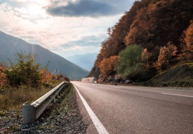 Georgia 'da güneş ışığıyla kaplı dağ yolu ve gökyüzü