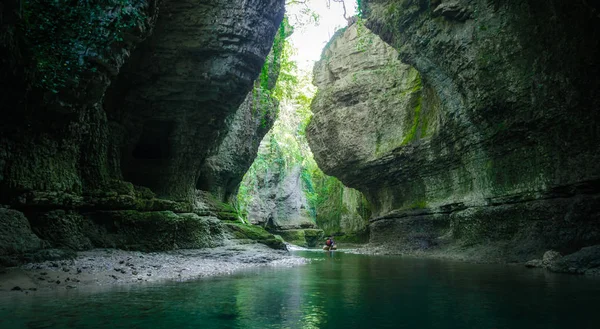Gürcistan 'da bir kanyonda dağ nehri ve turistler.