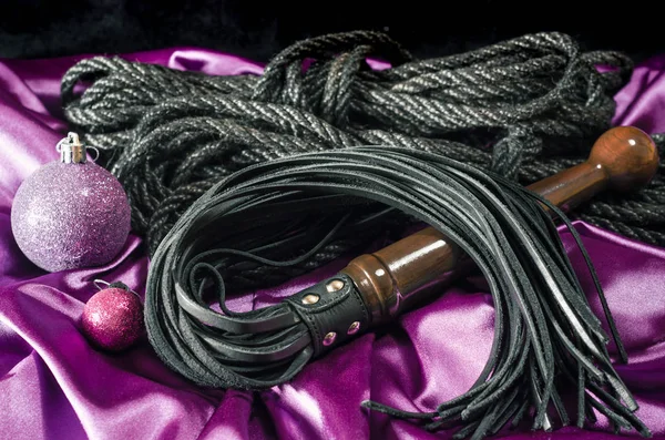 bdsm still life black skin whip rope shibari and Christmas ball 