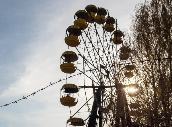 Arame farpado e cabines roda de carrossel em um parque de diversões abandonado — Fotografia de Stock