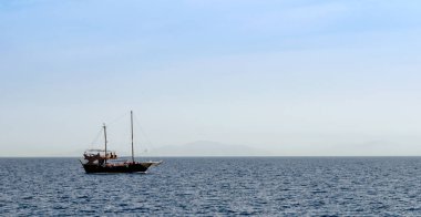 Adanın arka planında, Kızıl Deniz 'de siyah bir yat.