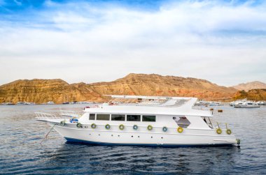 Sharm El Sheikh Mısır 'ın kayalık kıyılarından Kızıl Deniz' de turist beyaz teknesine binin.