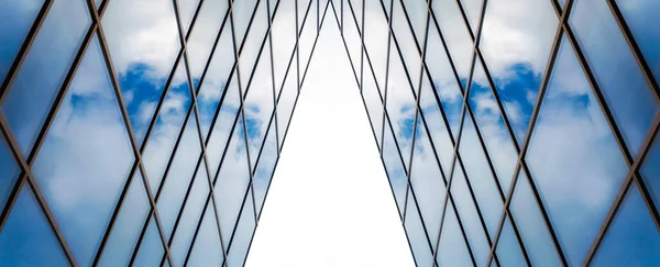 高いオフィスビルの窓に白い雲のある青い空の反射抽象的な建築的背景 — ストック写真
