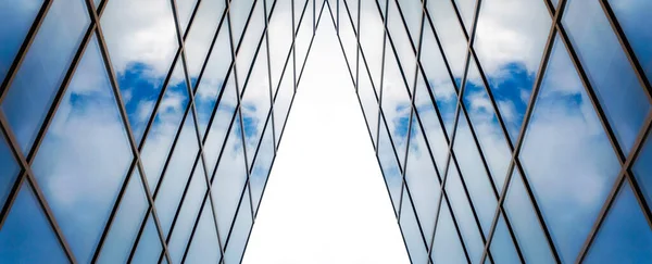 Uzun bir ofis binasının penceresinde beyaz bulutlu mavi gökyüzünün yansıması soyut mimari arka plan