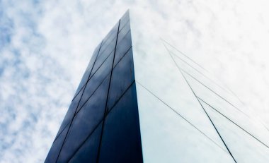 Gökyüzüne karşı modern bir bina duvarı ve soyut mimari arka plan bulutları