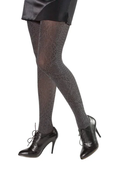 Siyah ayakkabılı güzel bacaklar beyaz arka planda izole edilmiş.