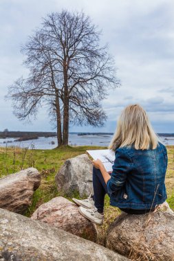 Peyzaj ressamı beyaz bir çarşaf üzerine bir çizim yapar.