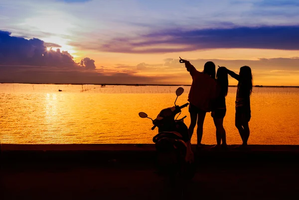 Mutlu genç kızlar standind günbatımı zamanı plajda grup — Stok fotoğraf