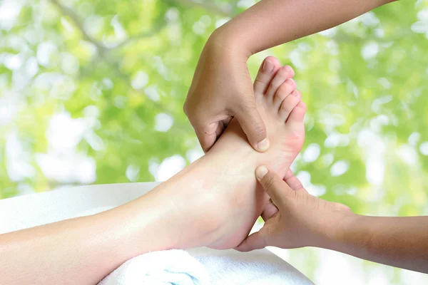 Masseur doing reflexology,Thai foot massage in spa on nature bac Stock Photo