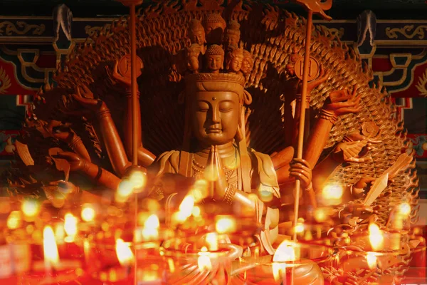 Guan Yin sculpture Thousand Hand carved of wood with candle ligh — Stock Photo, Image