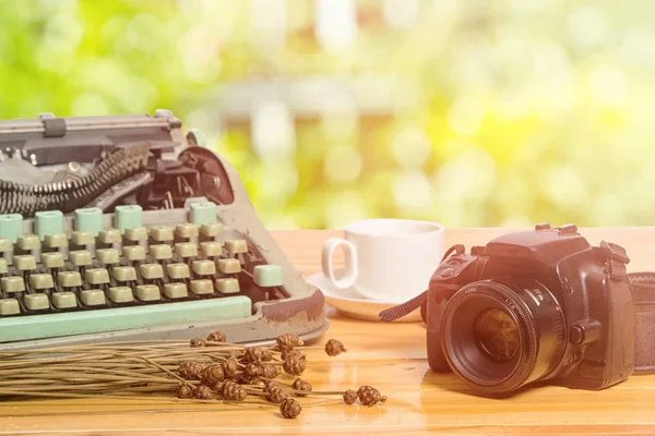 Vintage typewriter and camera on green bright blur background — Stock Photo, Image