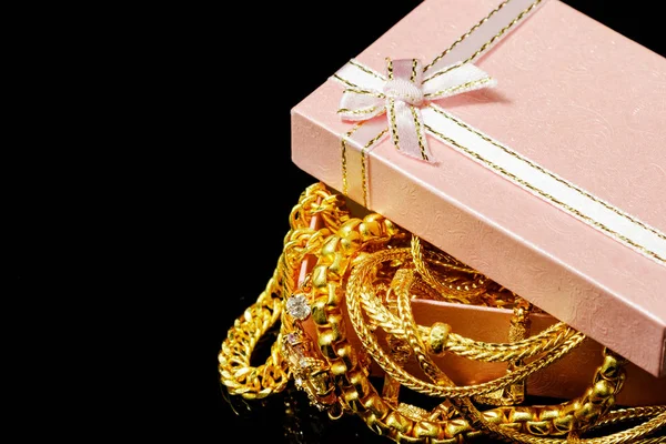 Goldschmuck mit Geschenkschachteln auf schwarzem Hintergrund — Stockfoto