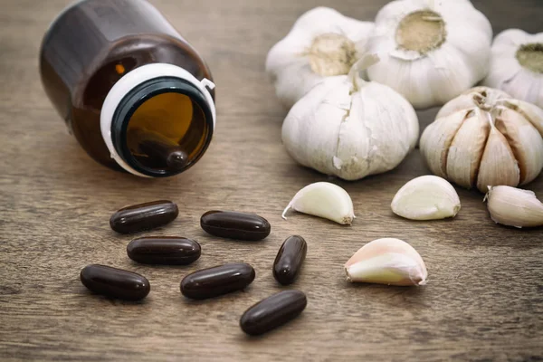 Garlic and garlic herbal capsules, alternative medicine — Stock Photo, Image