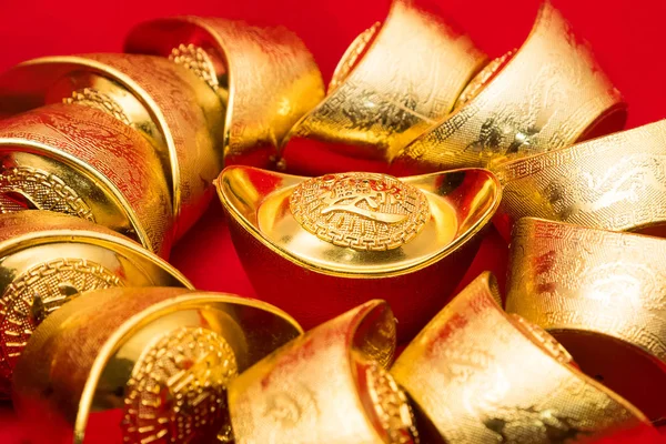 Пачка китайских золотых слитков на красном фоне. (text translation — стоковое фото