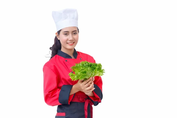 Lachende vrouw van de chef-kok in het rode uniform houden van plantaardige — Stockfoto