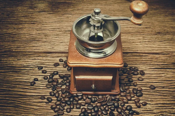 Moedor de café velho e grãos de café em fundo de madeira — Fotografia de Stock