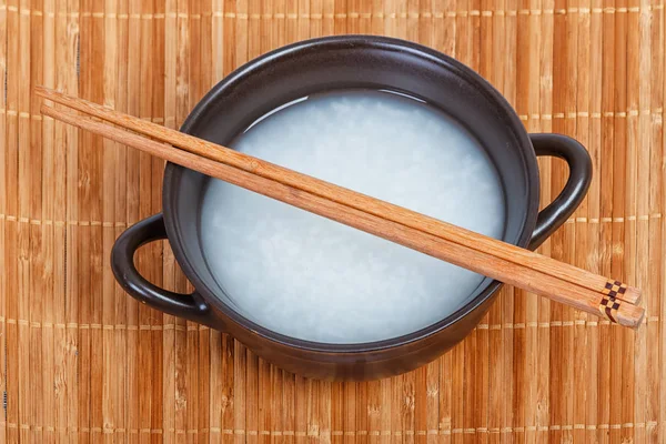 Cuenco de gachas de arroz o arroz hervido suave con palillos de madera — Foto de Stock