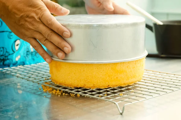 Cook taking out layer cake from cake form — Stock Photo, Image