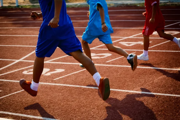 Grupo de meninos correndo em pista de corrida no estádio — Fotografia de Stock