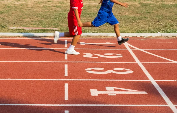 Pojkar kör på löparbana på arenan — Stockfoto