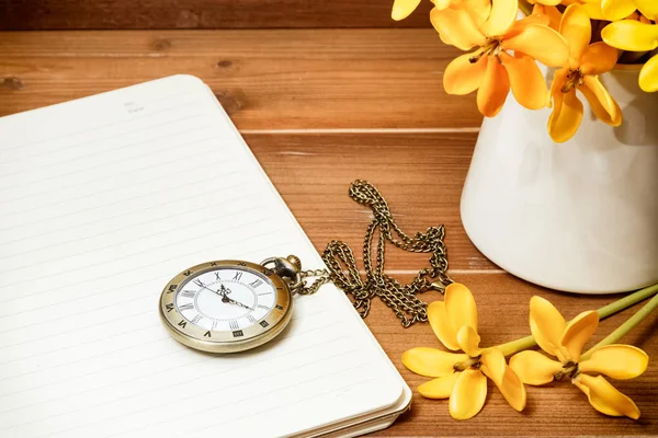 Reloj de bolsillo antiguo con flor de gardenia amarilla en respaldo de madera — Foto de Stock