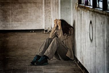 Katta köşedeki oturan korkmuş kötü muamele görmüş kadın