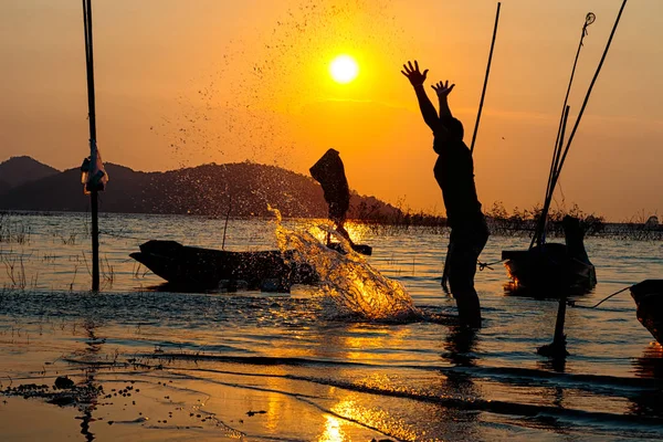 Silhouette de pêcheurs profiter au bord du lac pendant l'heure du coucher du soleil — Photo