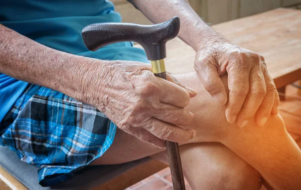 Wrinkled hand of old senior man with a cane stick — Stock Photo, Image