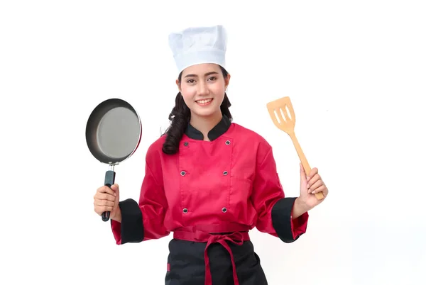 Mujer sonriente chef en uniforme sosteniendo utensilios de cocina —  Fotos de Stock