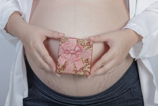 Femme enceinte tenant une boîte cadeau — Photo