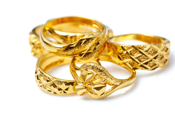 Grupo de muchos anillos de oro de diseño sobre fondo blanco —  Fotos de Stock