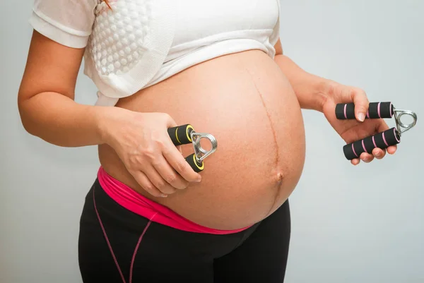 Gravid kvinna gör övningar, moderskap friska koncept — Stockfoto