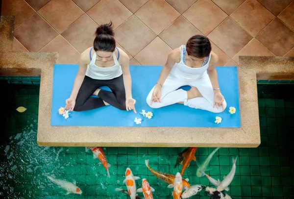 Pareja joven practicando yoga en posición de loto al aire libre —  Fotos de Stock
