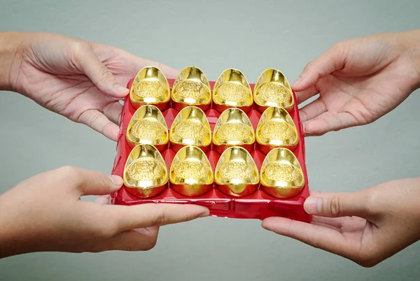Main donnant lingot d'or à quelqu'un pour le Nouvel An chinois celebrati — Photo