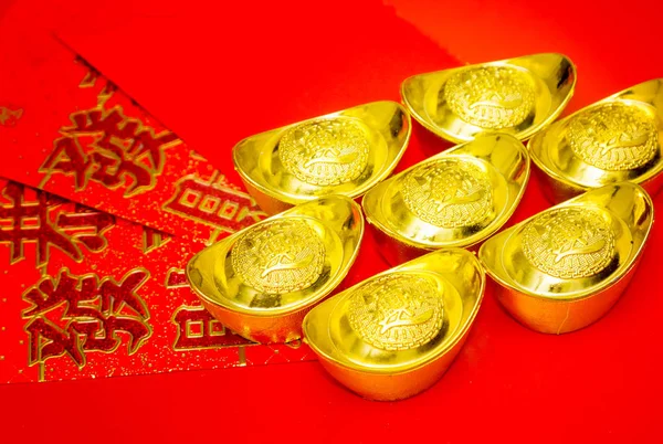Adornos chinos de año nuevo, paquetes rojos, lingotes de oro en ba blanca —  Fotos de Stock