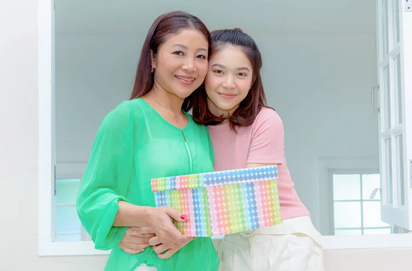 Presente para a mãe, mãe feliz e filha jovem segurar presente para — Fotografia de Stock