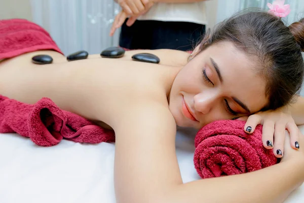 Terapii masaż gorącymi kamieniami, masaż młoda kobieta coraz gorącymi kamieniami — Zdjęcie stockowe