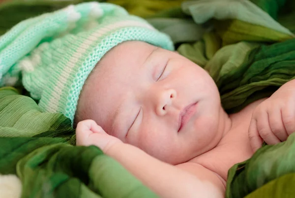 Bebé recién nacido niña está durmiendo en manta de tela verde —  Fotos de Stock