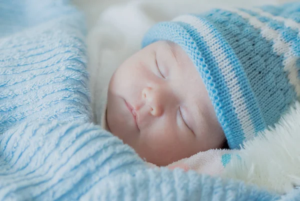 Bebé recién nacido niña está durmiendo con un bebé sombrero de punto —  Fotos de Stock
