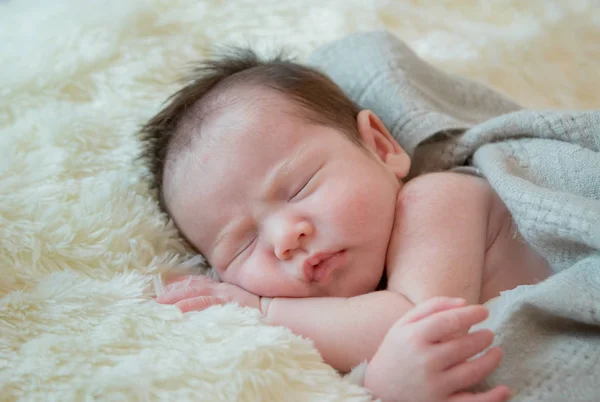 Pasgeboren babymeisje is slapen op bont deken — Stockfoto