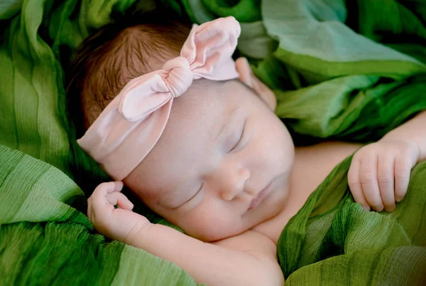 Newborn baby girl is sleeping on green fabric blanket — Stock Photo, Image